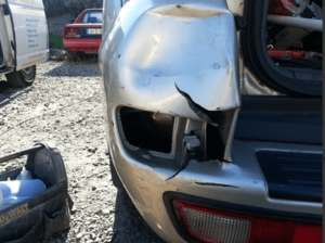 Major crash damage and dented plastic bumper